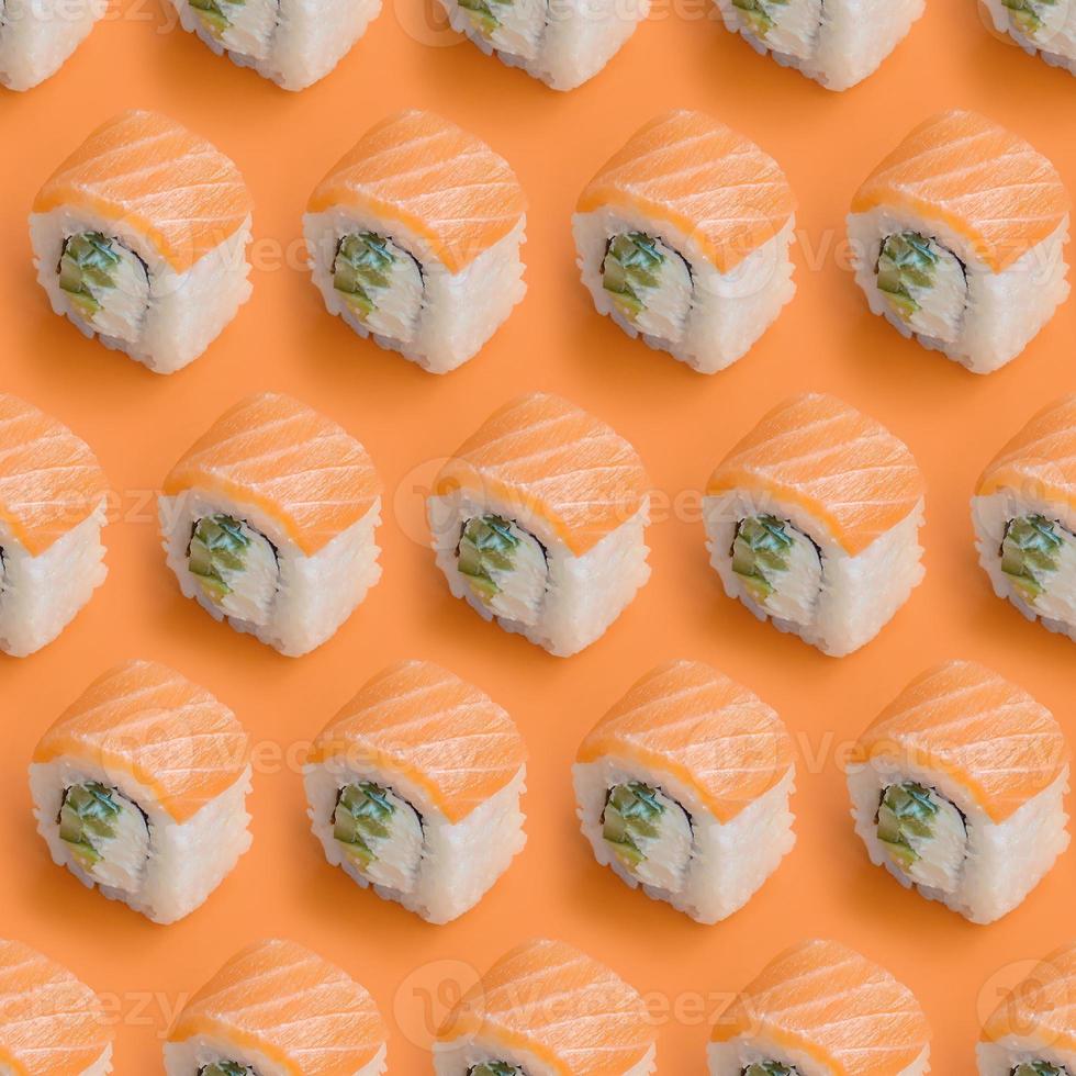 Philadelphia rolls with salmon on orange background. Minimalism top view flat lay pattern with Japanese food photo