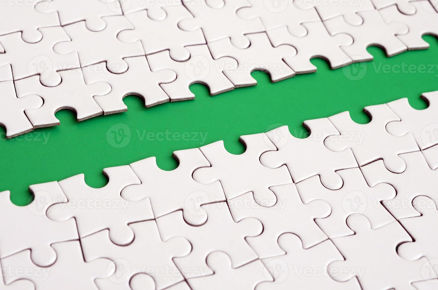 The green path is laid on the platform of a white folded jigsaw puzzle. Texture image with copy space for text photo
