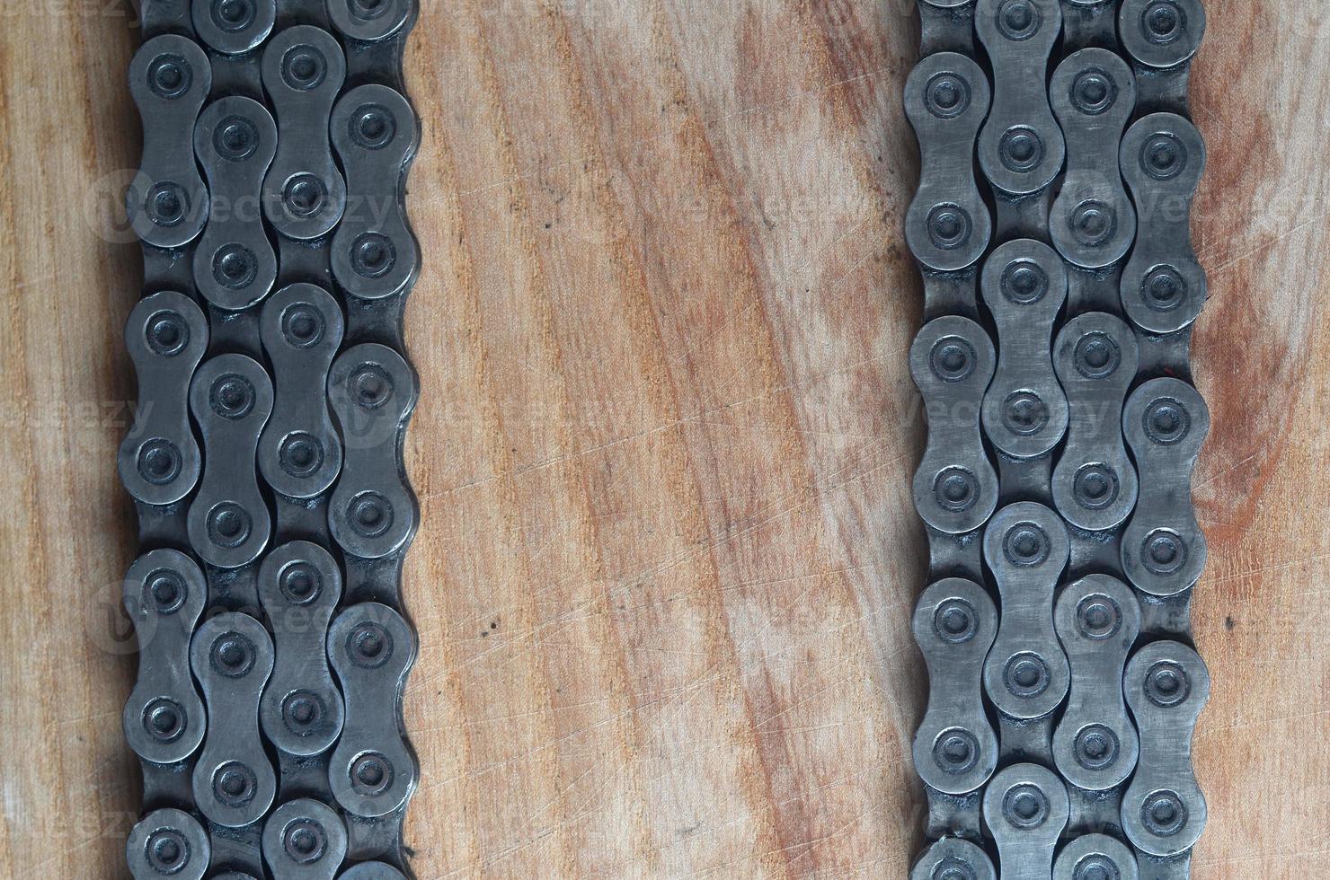 Dirty and oily chain from a mountain bike lying on a wooden table in a bicycle shop photo