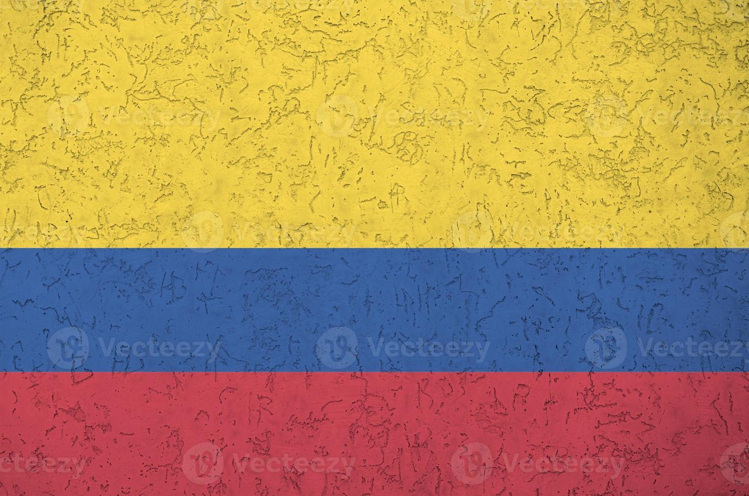 Colombia flag depicted in bright paint colors on old relief plastering wall. Textured banner on rough background photo