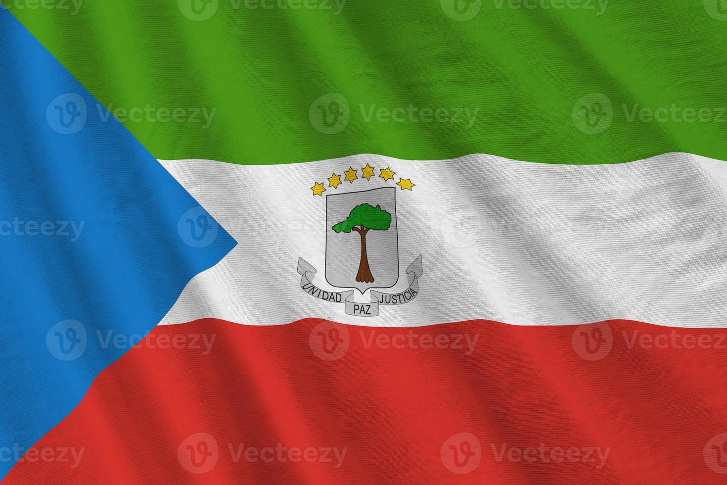 Equatorial Guinea flag with big folds waving close up under the studio light indoors. The official symbols and colors in banner photo