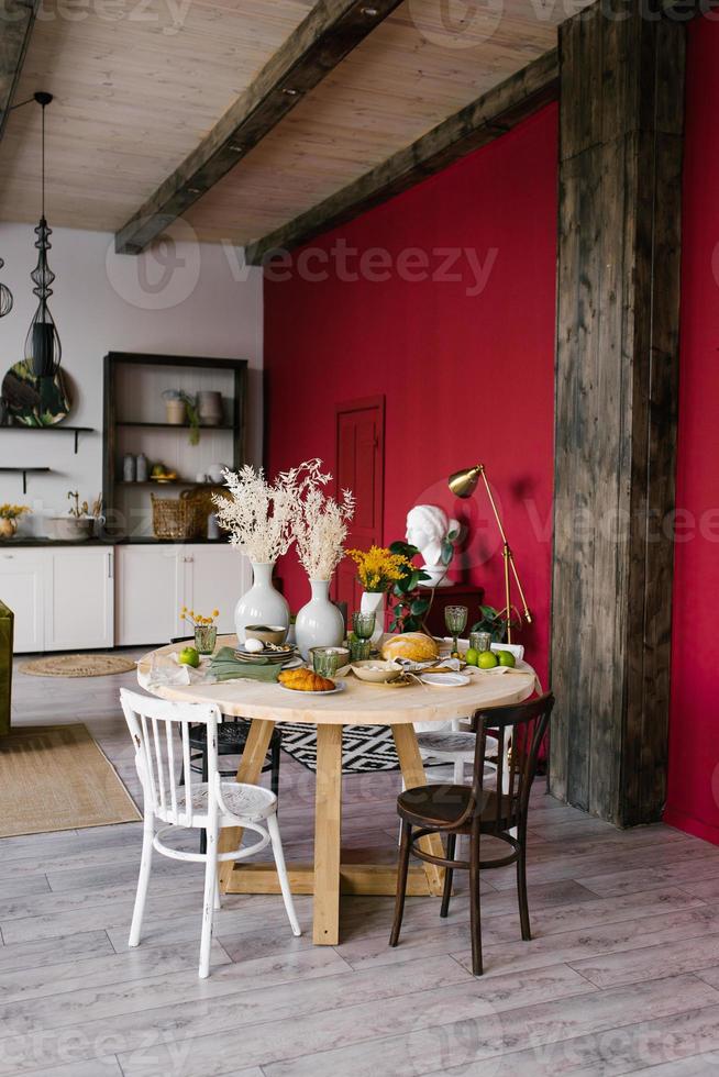 Round dining table with different chairs in the interior of a modern bright living room photo