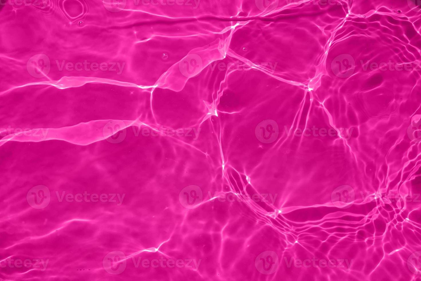 Defocus blurred transparent purple colored clear calm water surface texture with splash, bubble. Shining purple water ripple background. Surface of water in swimming pool. Purple bubble water shine. photo