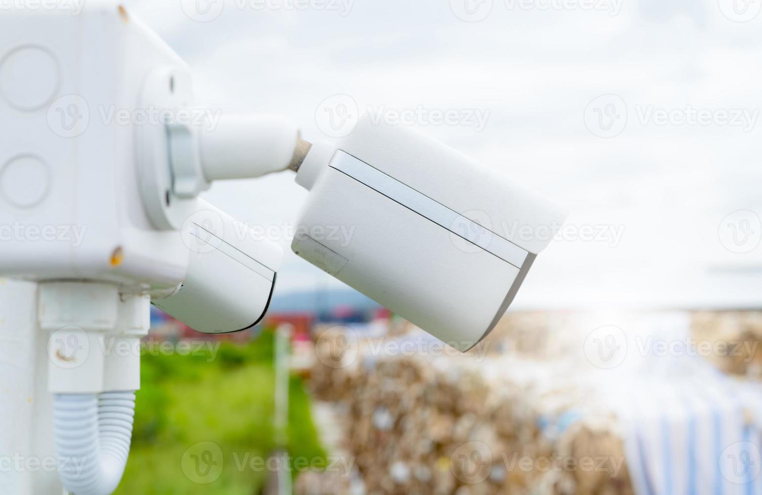 Side view of white CCTV security camera video system for safety at a paper recycling factory. Closed-circuit television. CCTV electronic security system. Video surveillance camera technology. photo