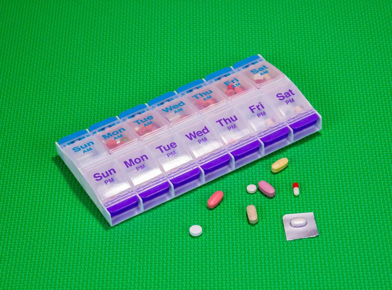Medical Pills And Pill Container On Green Pattern Background photo