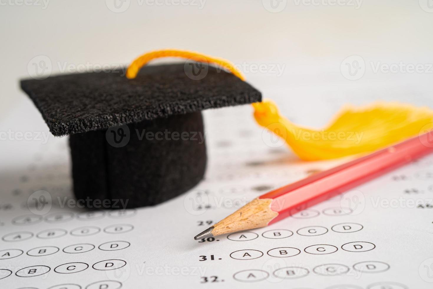 sombrero de graduación y lápiz en el fondo de la hoja de respuestas, concepto de enseñanza de aprendizaje de matemáticas de estudio de educación. foto