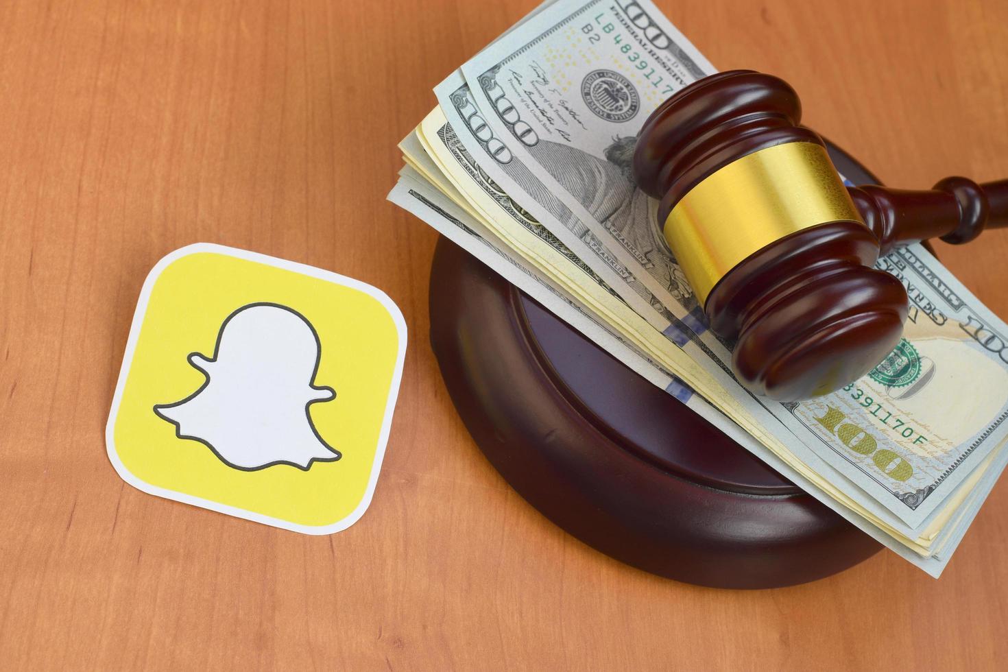 Judge Orders Premium Snapchat Model To Pay 60k KHARKOV, UKRAINE - MAY 3, 2022 Snapchat paper logo lies with judge