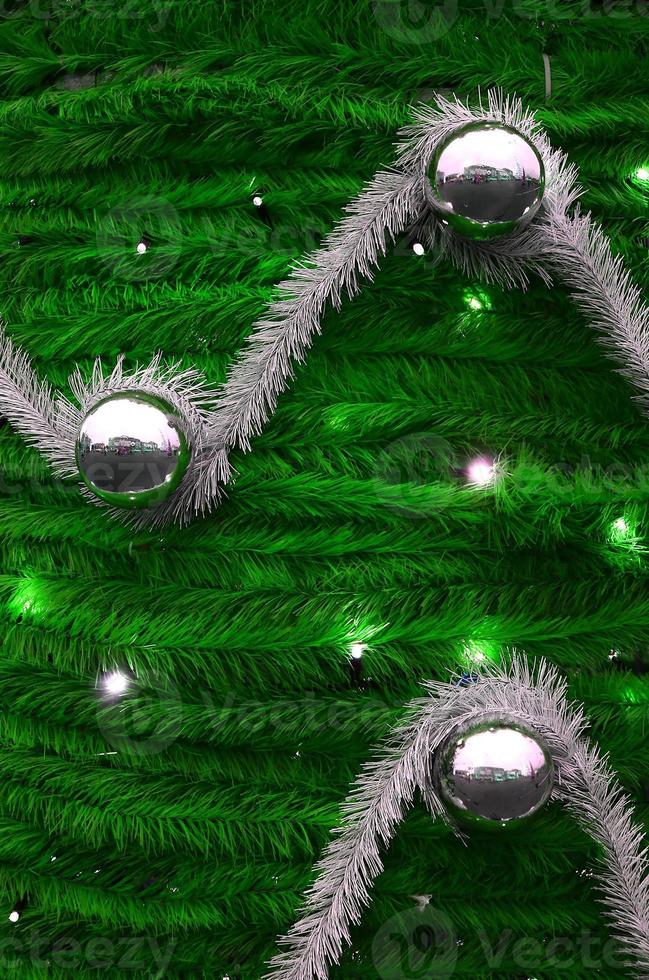 Texture of the wall decorated with New Year's fluffy ribbons and decorations in the form of glossy balls photo