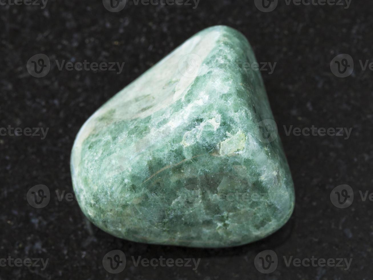 piedra preciosa de jadeíta verde pulida en la oscuridad foto