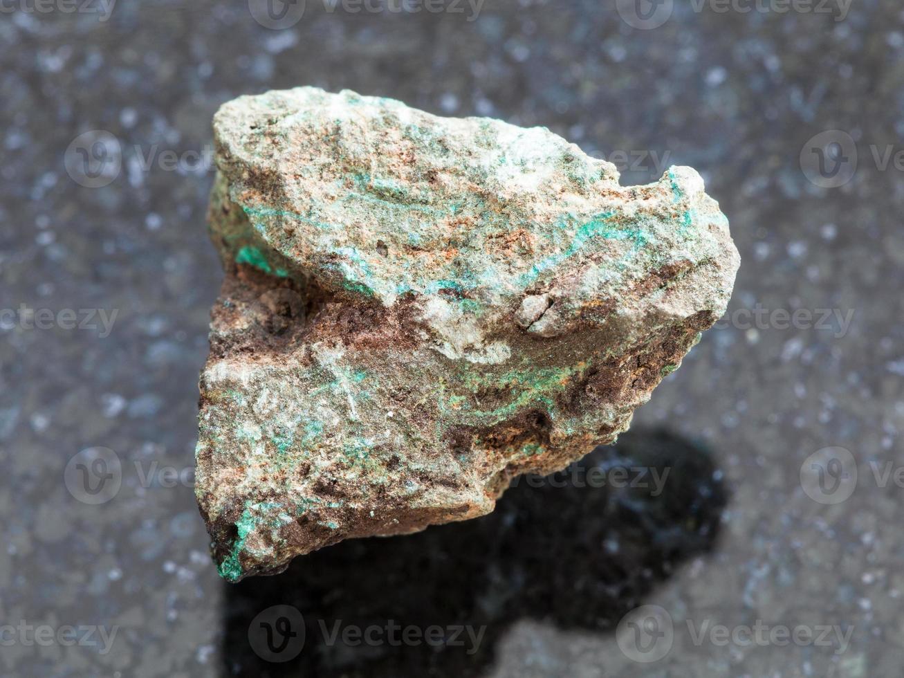 rough Malachite copper ore stone on dark photo