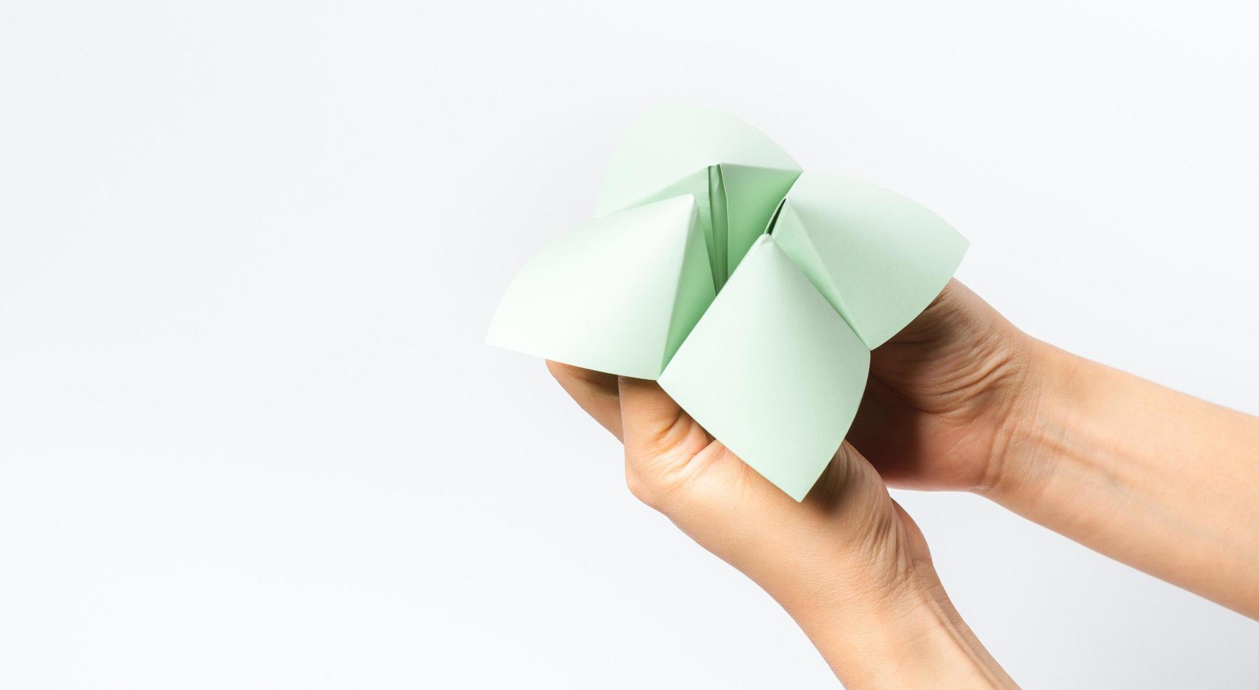 Hand in a paper fortune teller isolated on white background. photo