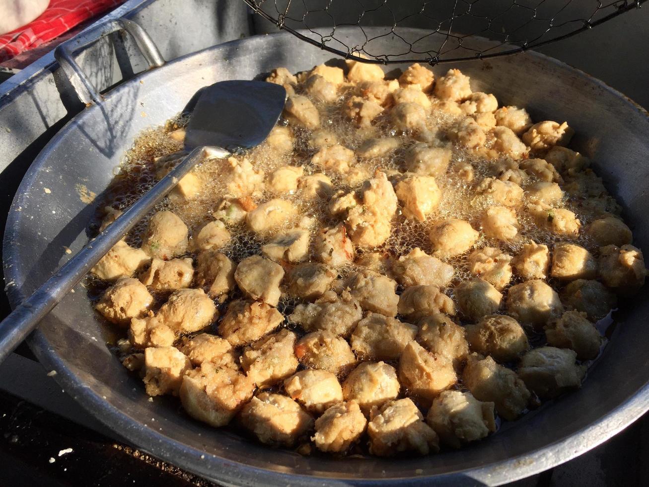 vista de cerca de los dumplings fritos de batagor en bandung, una comida callejera muy popular en indonesia, uno de los bocadillos locales servidos con salsa de maní foto