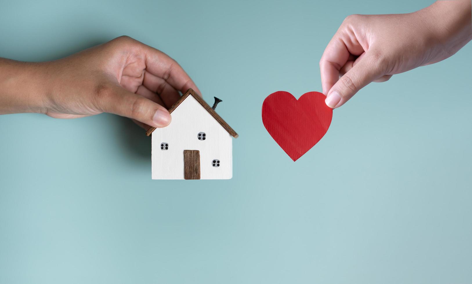 Hands holding house and heart shape concept of new dream house. photo