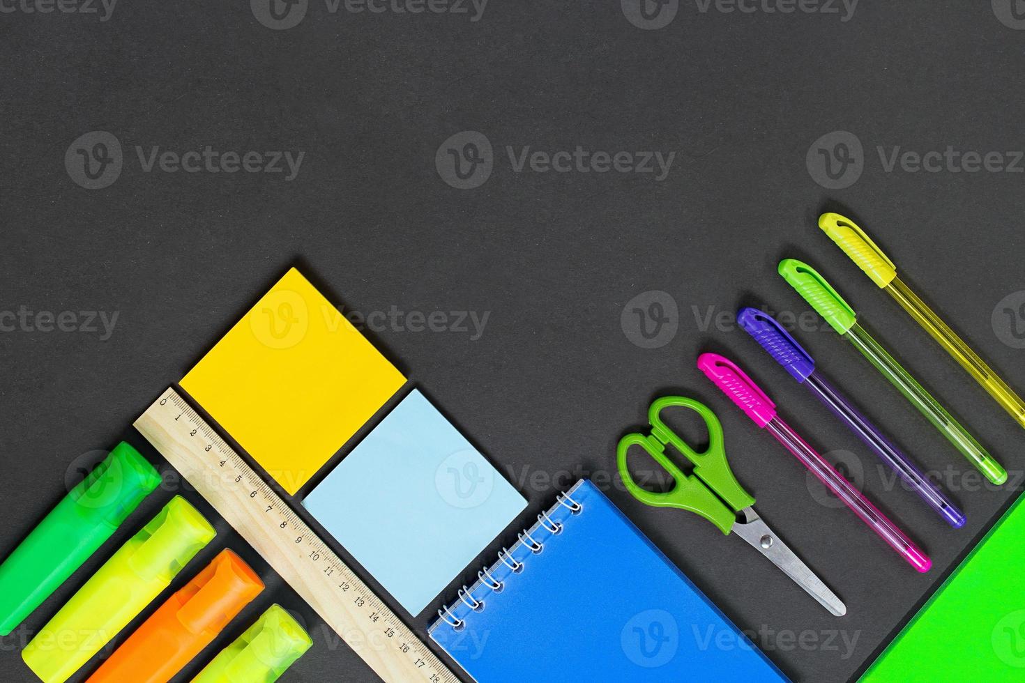 Stationery on black background or school board. Markers, pens, n photo