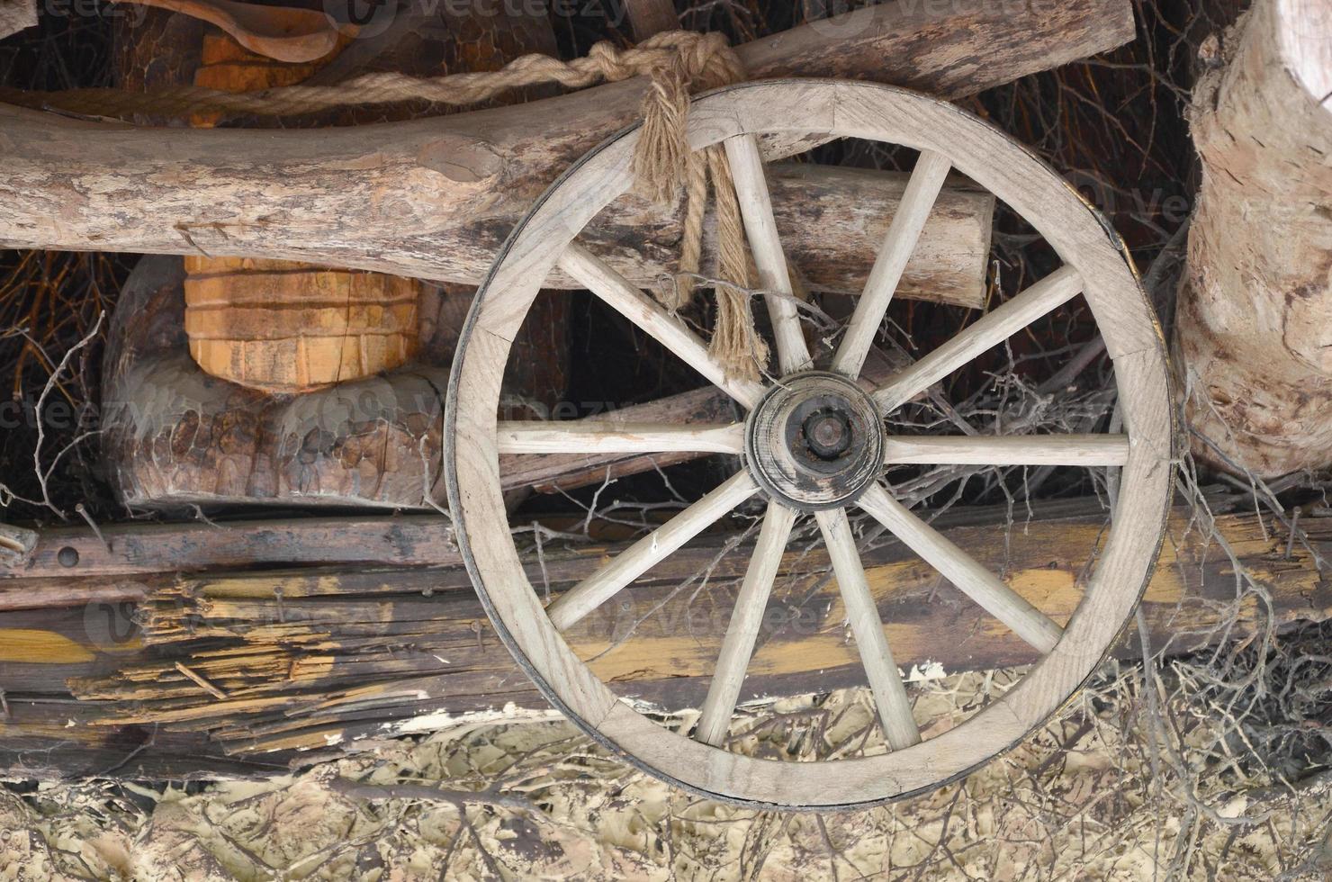 The old wooden wheel from the carriage hangs on the wall of the Ukrainian barn photo