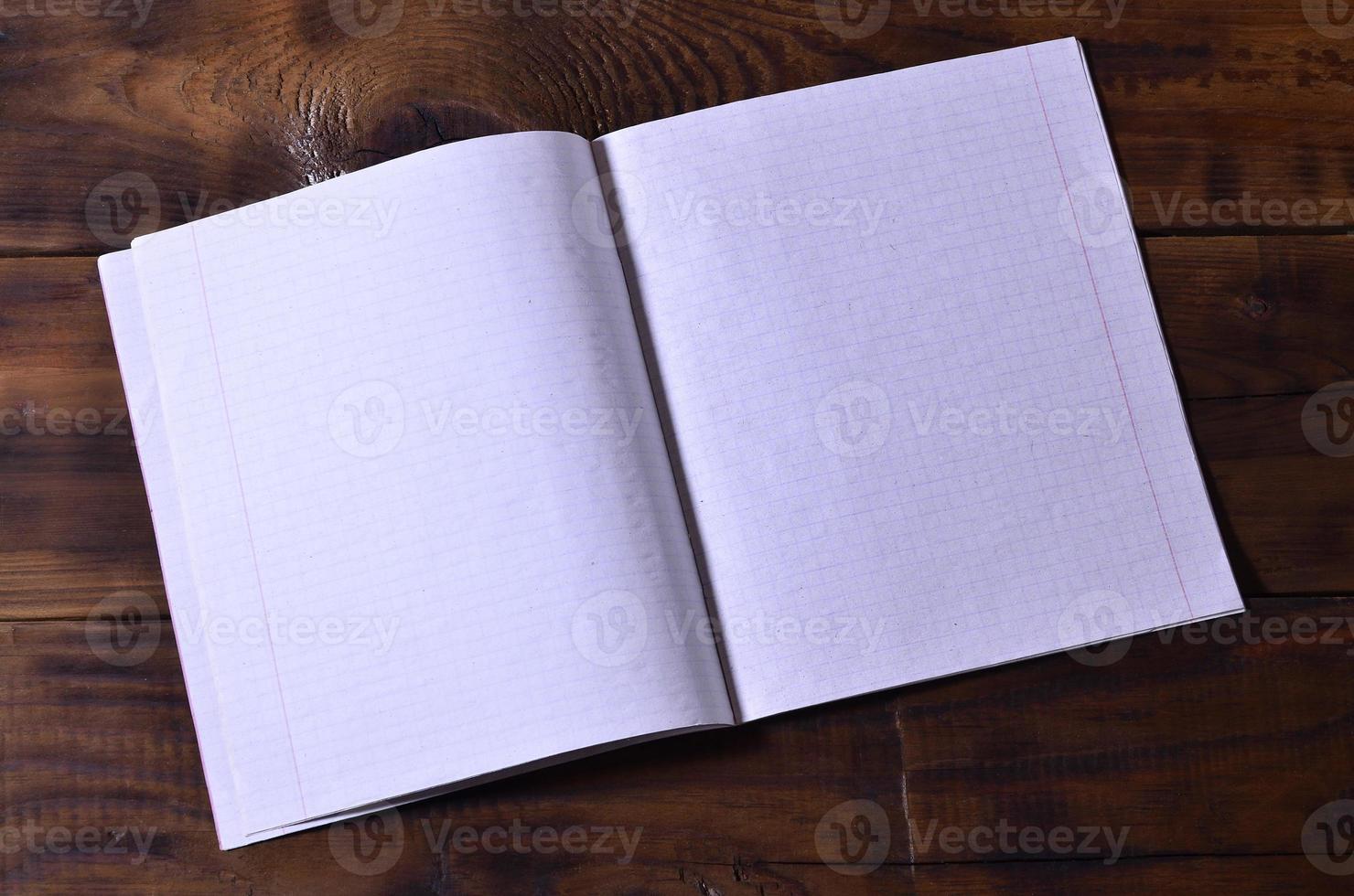 Photo of a clean white school checkbook on a brown wooden background. Idea or message concept. Plenty of space for text