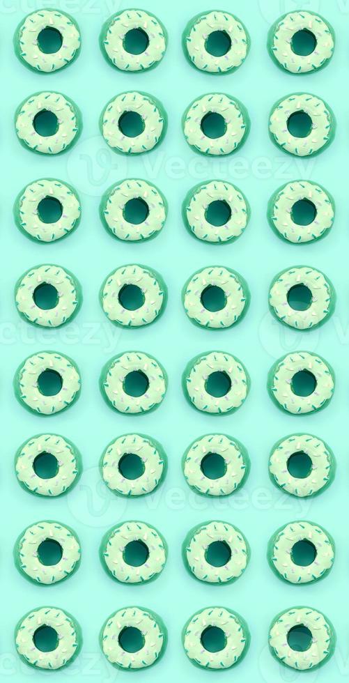 Many small plastic donuts lies on a pastel colorful background. Flat lay minimal pattern. Top view photo