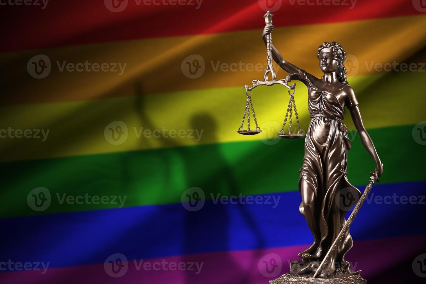 LGBT community flag with statue of lady justice and judicial scales in dark room. Concept of judgement and punishment photo