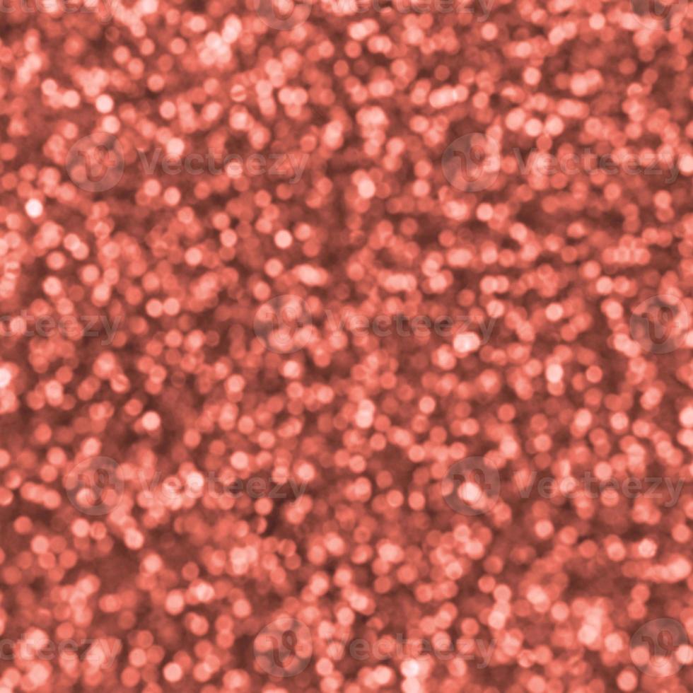 Blurred orange decorative sequins. Background image with shiny bokeh lights from small elements photo