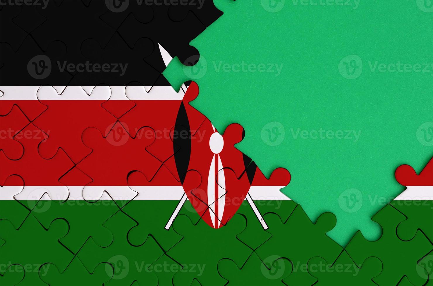 Kenya flag is depicted on a completed jigsaw puzzle with free green copy space on the right side photo