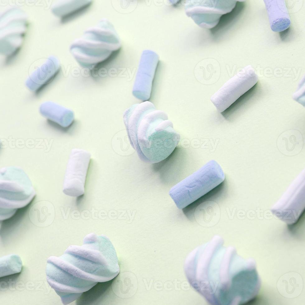 Colorful marshmallow laid out on lime paper background. pastel creative textured pattern photo