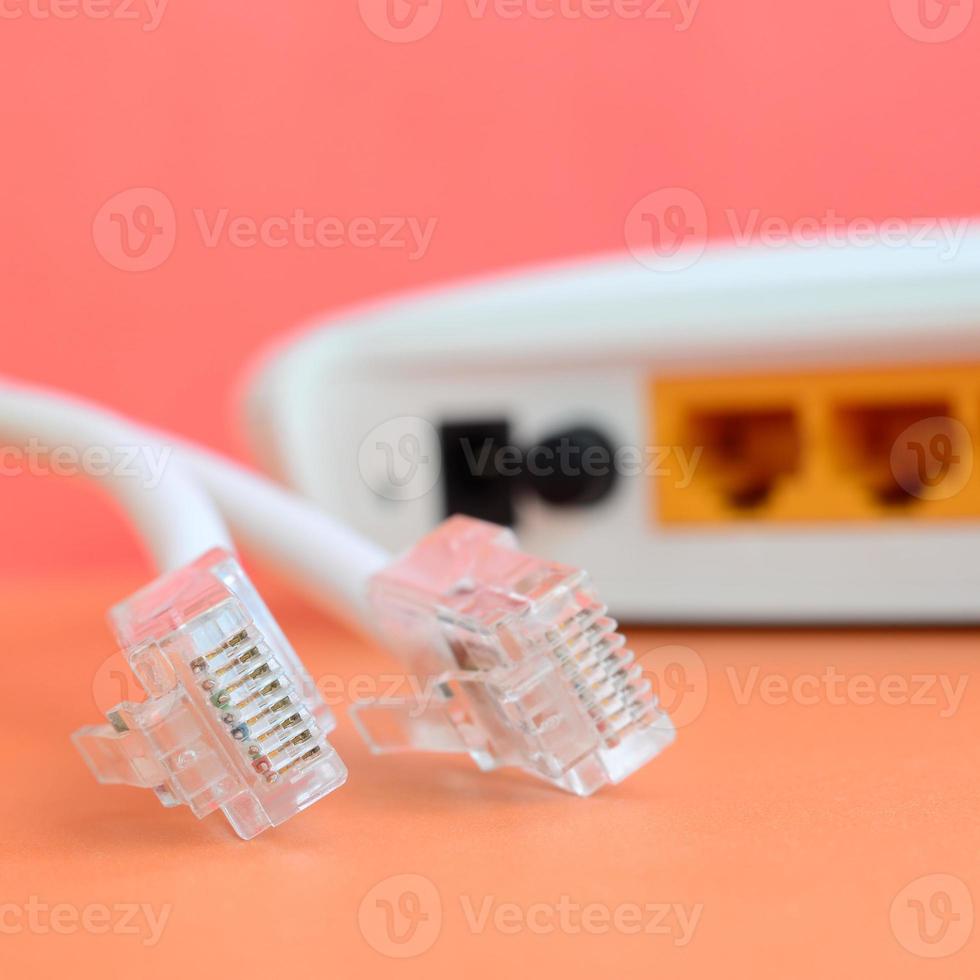 Internet router and Internet cable plugs lie on a bright orange background. Items required for Internet connection photo