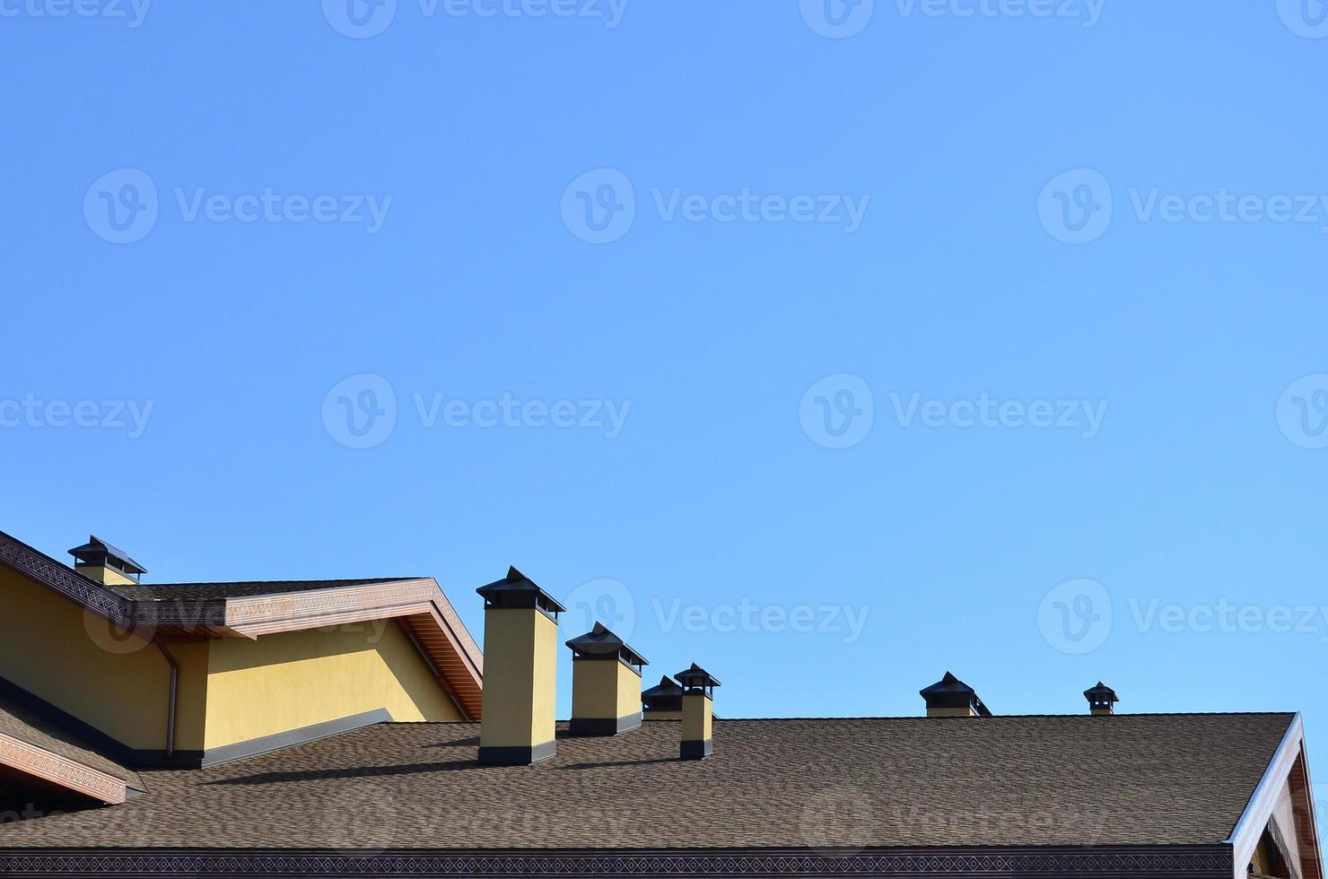 Modern roofing and decoration of chimneys. Flexible bitumen or slate shingles. The absence of corrosion and condensation due to the flexible roof photo