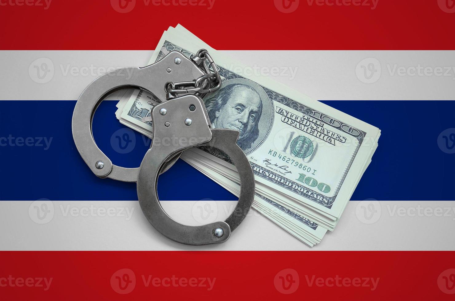Thailand flag  with handcuffs and a bundle of dollars. Currency corruption in the country. Financial crimes photo