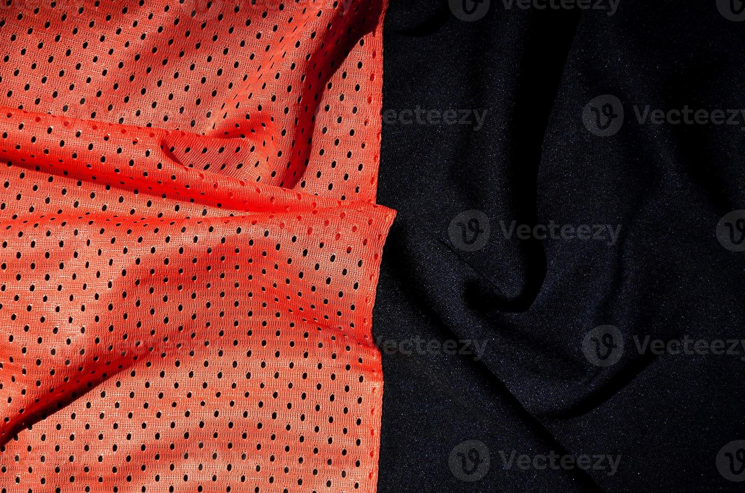 Sport clothing fabric texture background. Top view of red polyester nylon cloth textile surface. Colored basketball shirt with free space for text photo