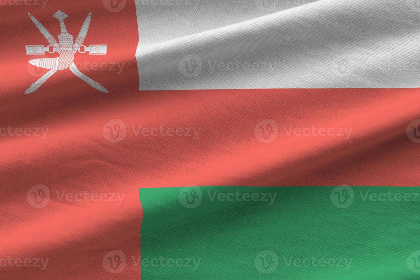 Oman flag with big folds waving close up under the studio light indoors. The official symbols and colors in banner photo