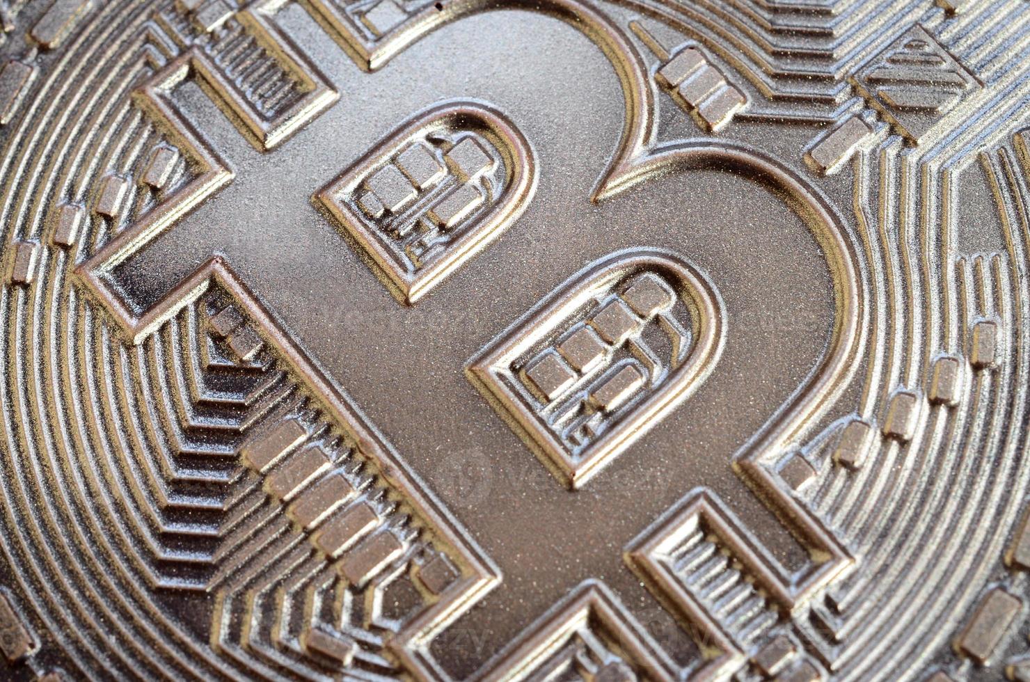 Close up shot of a physical bitcoin with a shiny relief surface made of chocolate. Abstract image of the crypto currency in an edible form photo