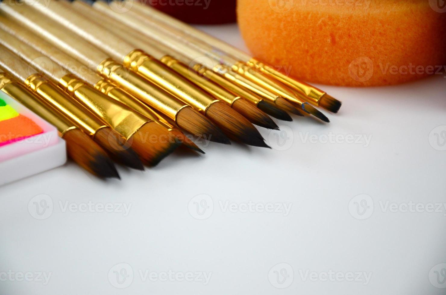 Color cosmetics, brushes and sponges for face painting on white background photo