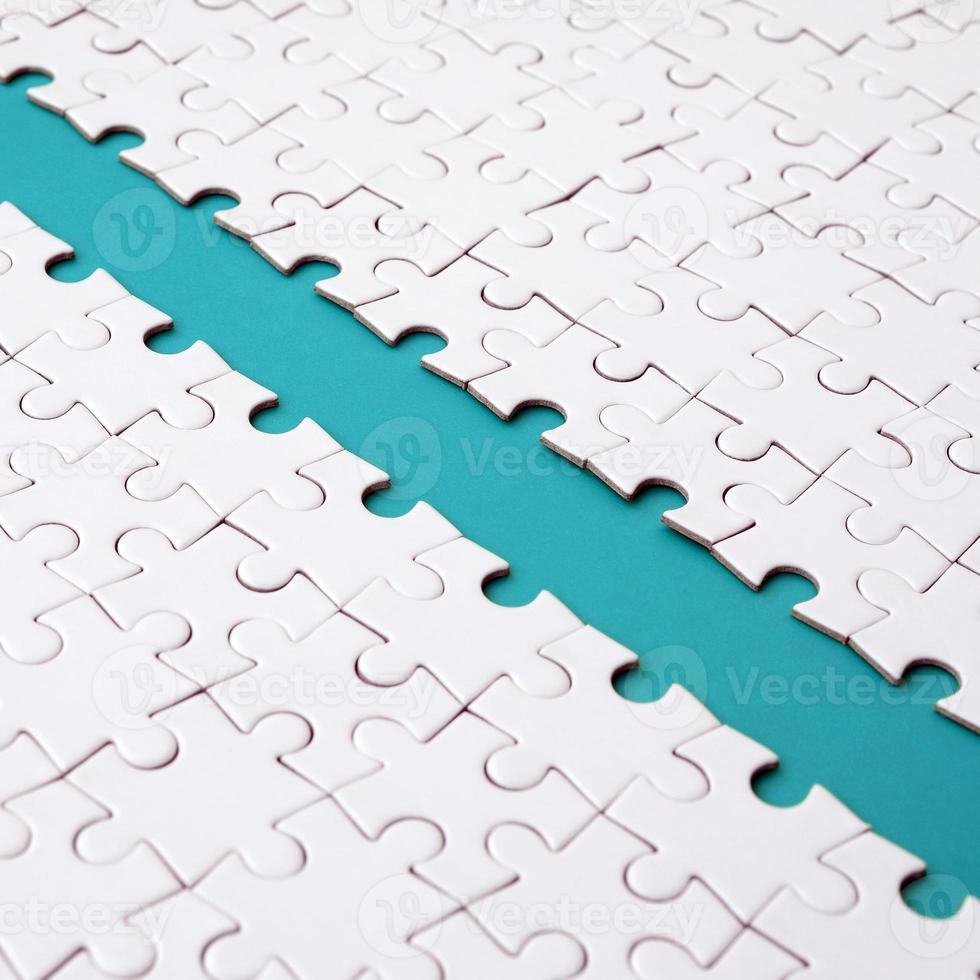 The blue path is laid on the platform of a white folded jigsaw puzzle. Texture image with copy space for text photo