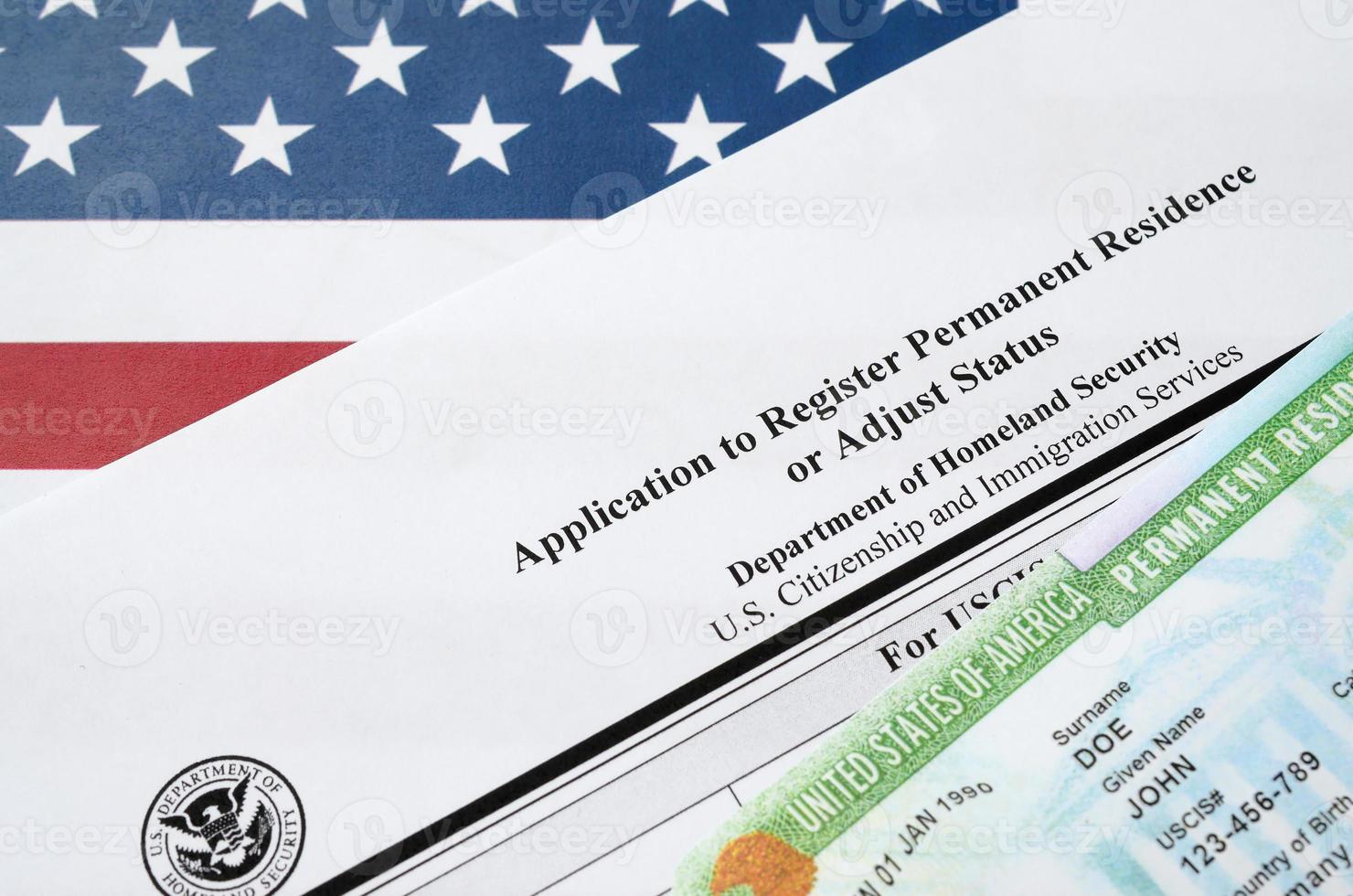 I-485 Application to register permanent residence or adjust status form and green card from dv-lottery lies on United States flag from Department of Homeland Security photo