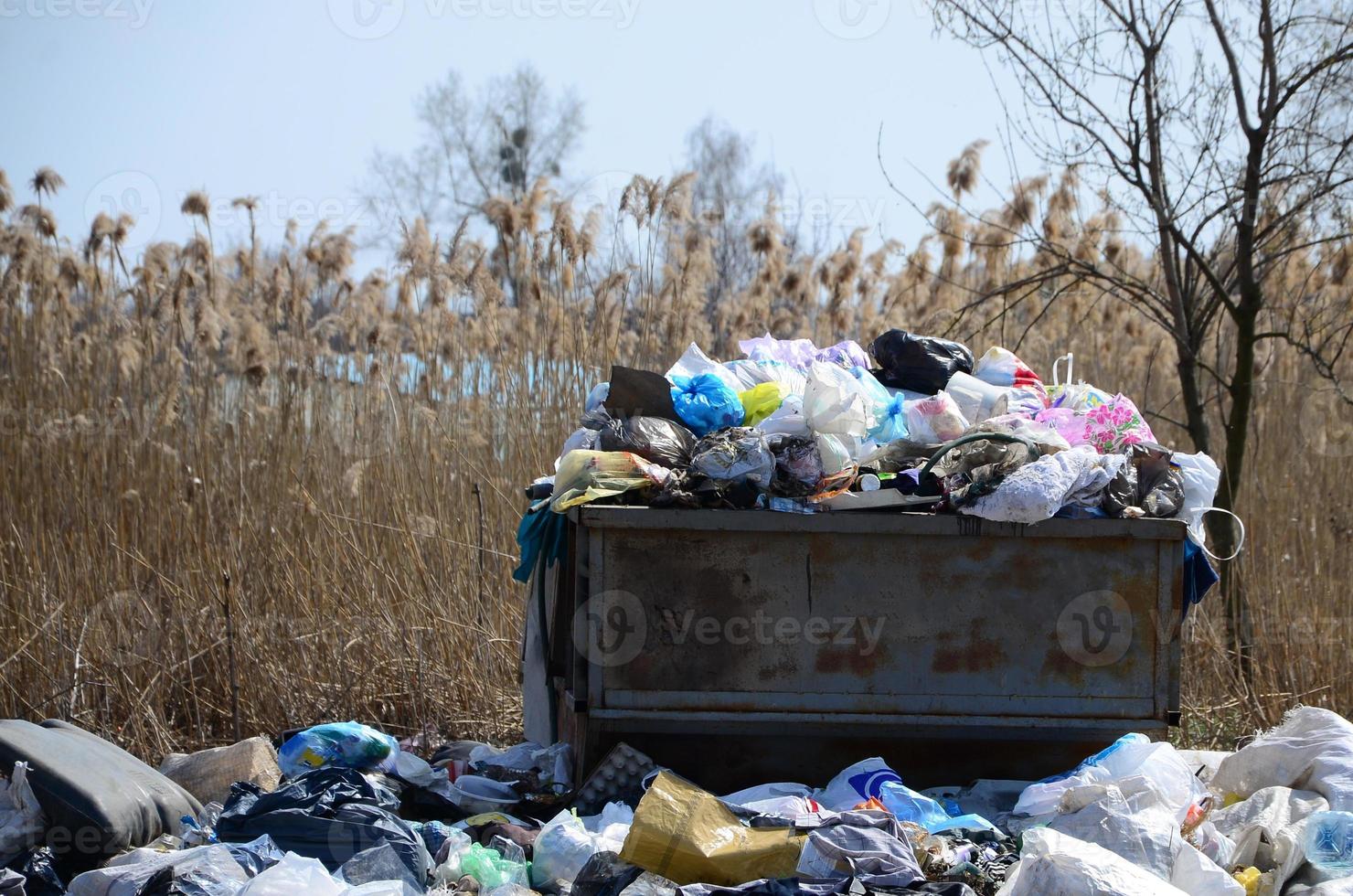 The garbage can is packed with garbage and waste. Untimely removal of garbage in populated areas photo