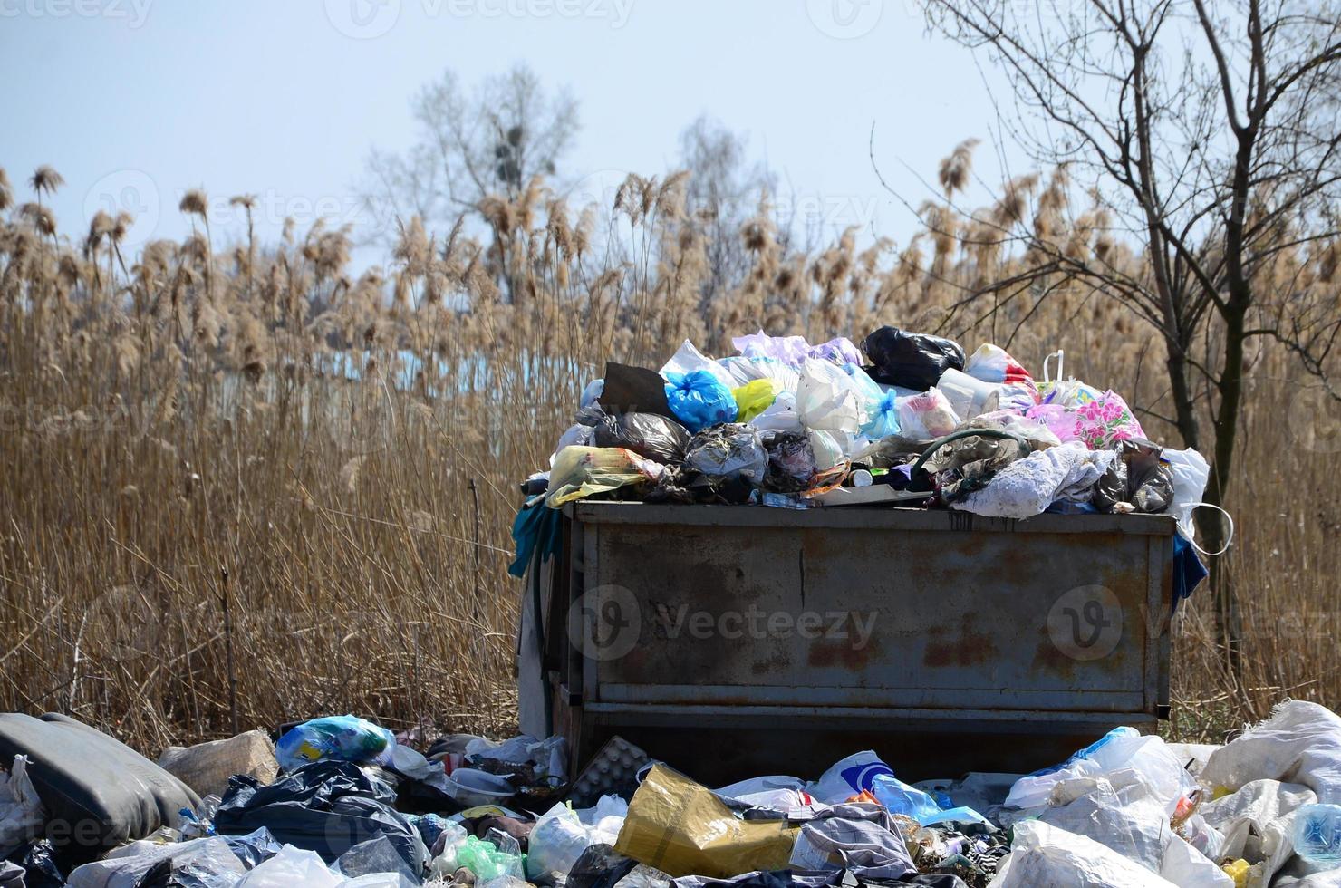 el bote de basura está lleno de basura y desechos. retiro intempestivo de basura en zonas pobladas foto