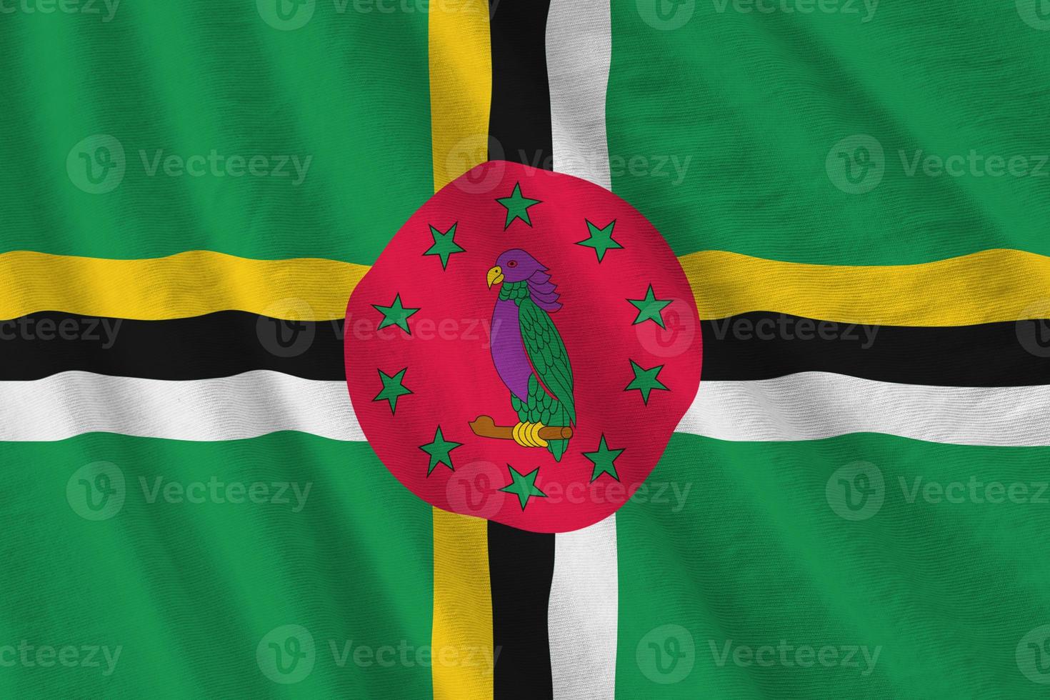 Dominica flag with big folds waving close up under the studio light indoors. The official symbols and colors in banner photo