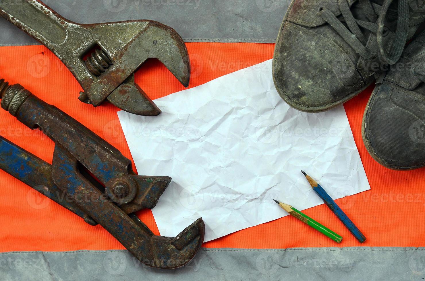 Adjustable wrenches with old boots and a sheet of paper with two photo