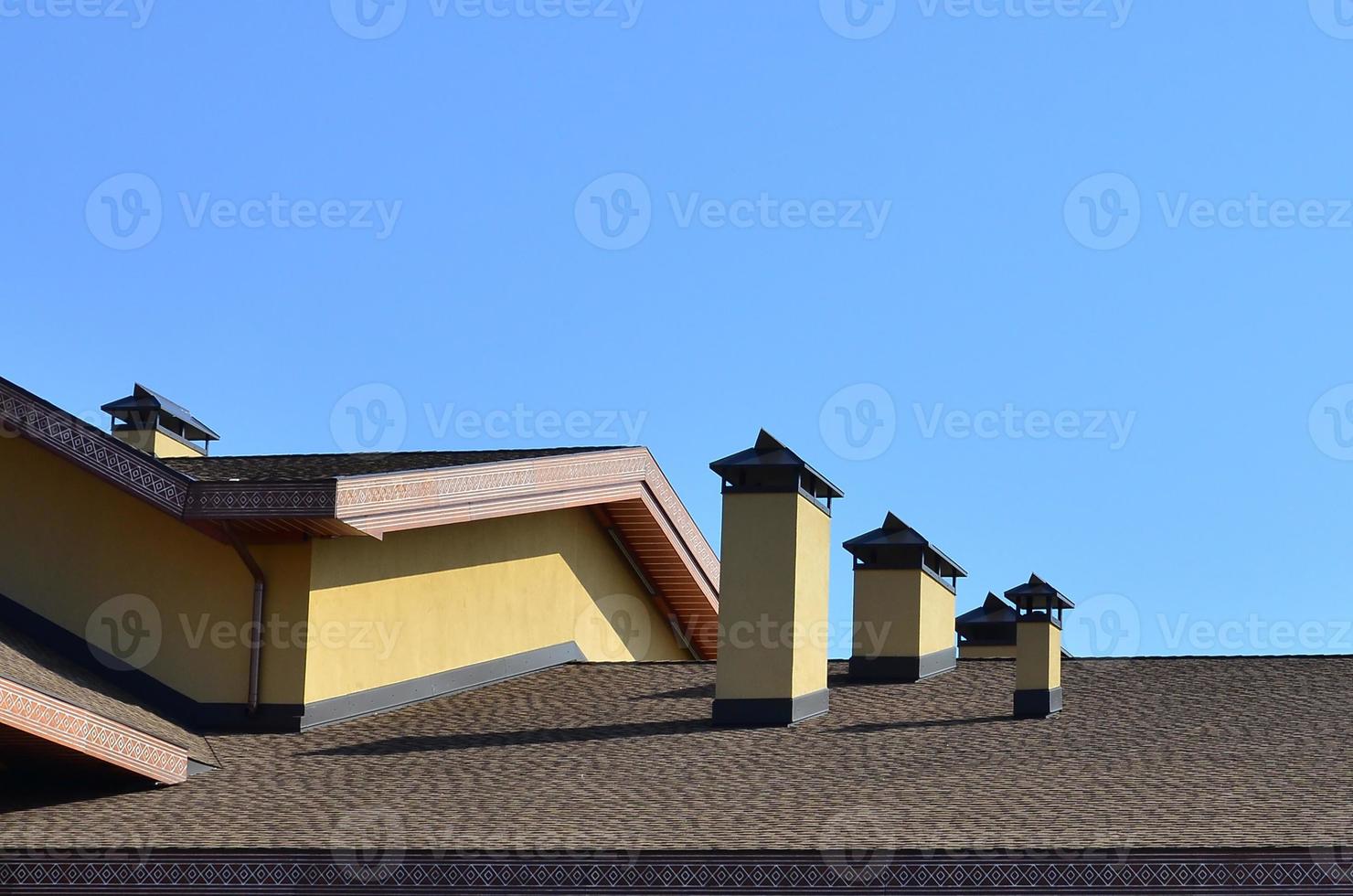 Modern roofing and decoration of chimneys. Flexible bitumen or slate shingles. The absence of corrosion and condensation due to the flexible roof photo