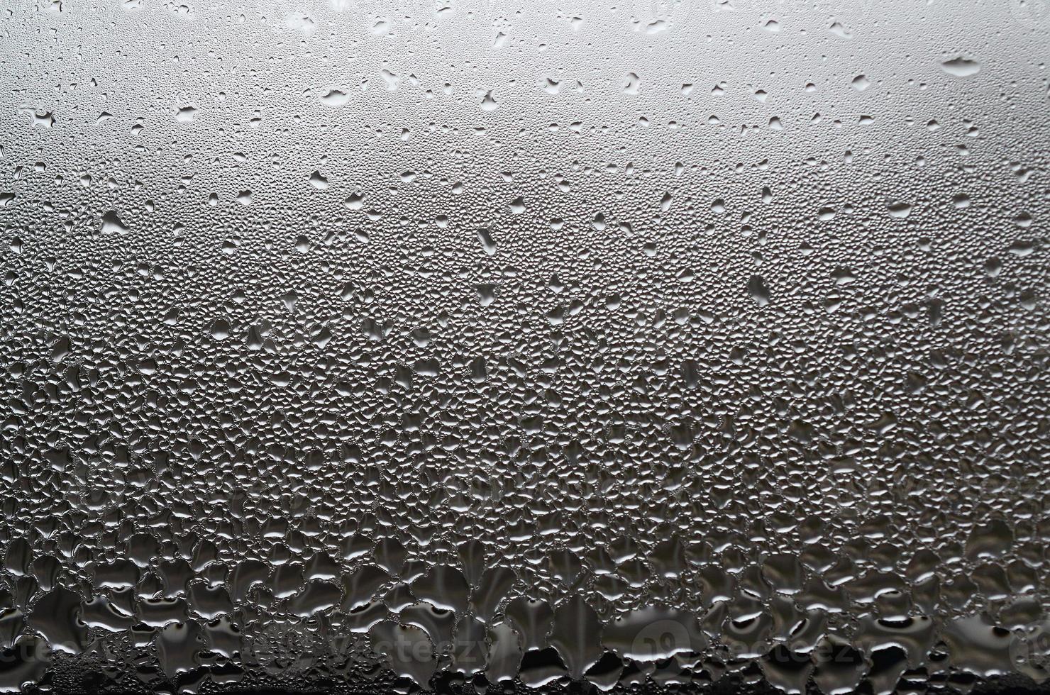 una foto de la superficie de vidrio de la ventana, cubierta con una multitud de gotas de varios tamaños. textura de fondo de una densa capa de condensado sobre vidrio