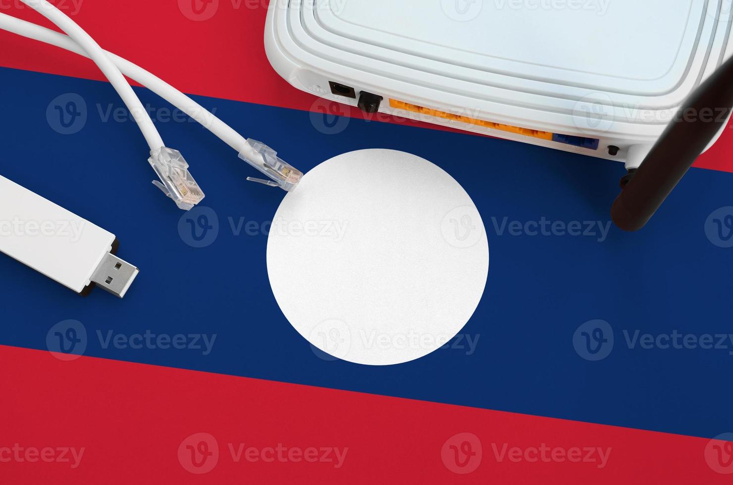 Laos flag depicted on table with internet rj45 cable, wireless usb wifi adapter and router. Internet connection concept photo