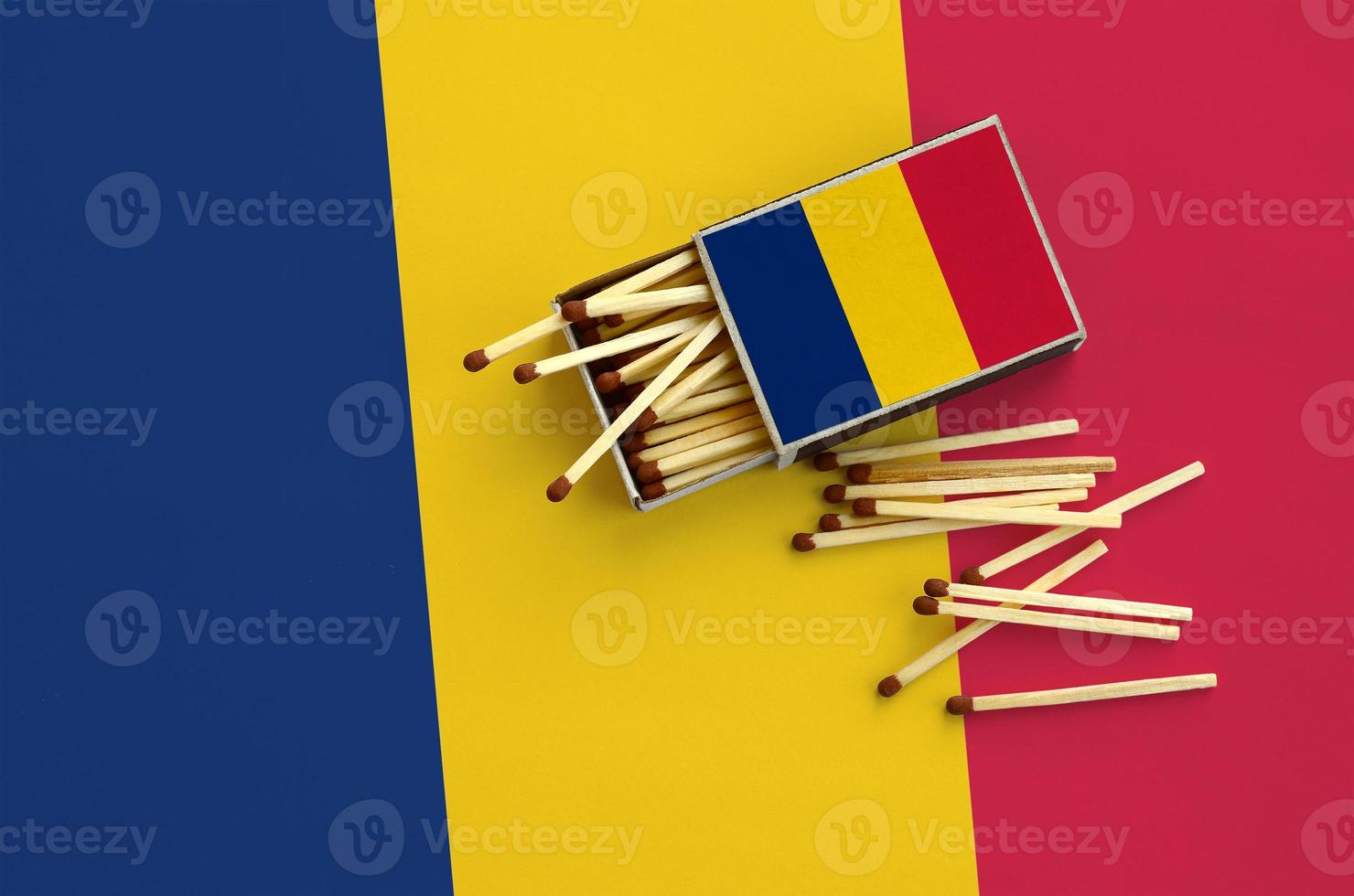 Chad flag is shown on an open matchbox, from which several matches fall and lies on a large flag photo