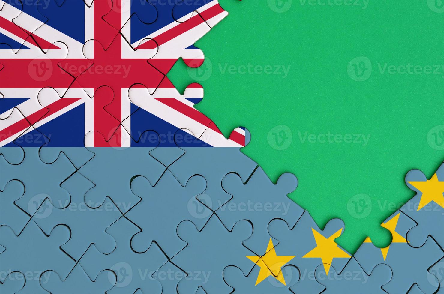 Tuvalu flag is depicted on a completed jigsaw puzzle with free green copy space on the right side photo