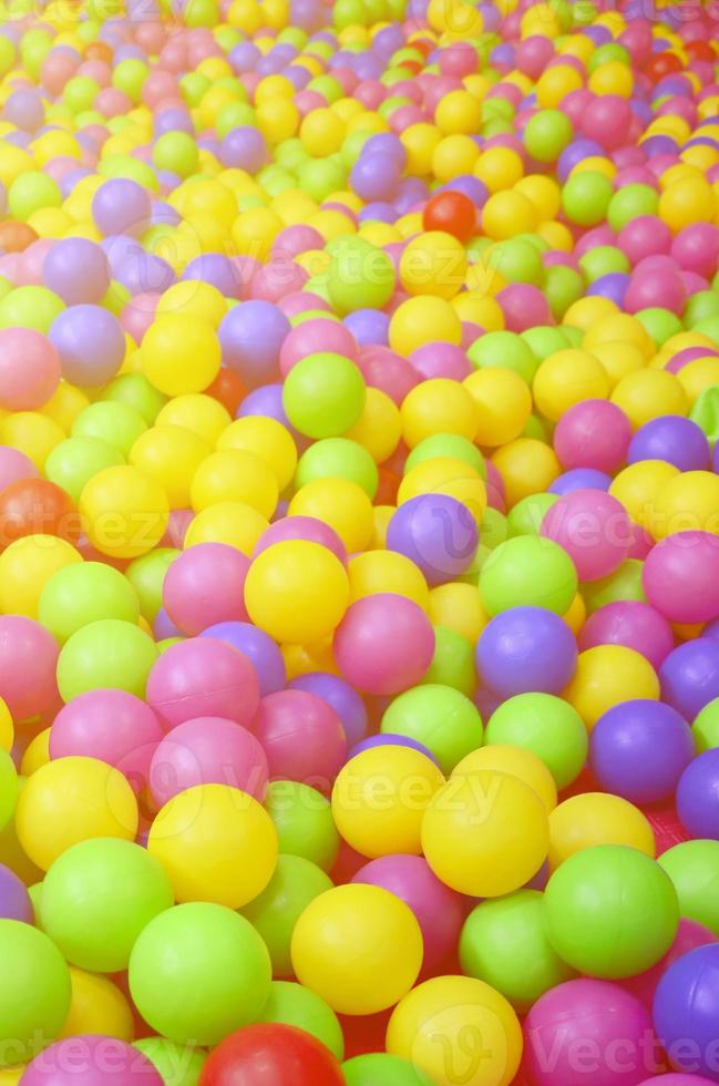 Many colorful plastic balls in a kids' ballpit at a playground. Close up pattern photo