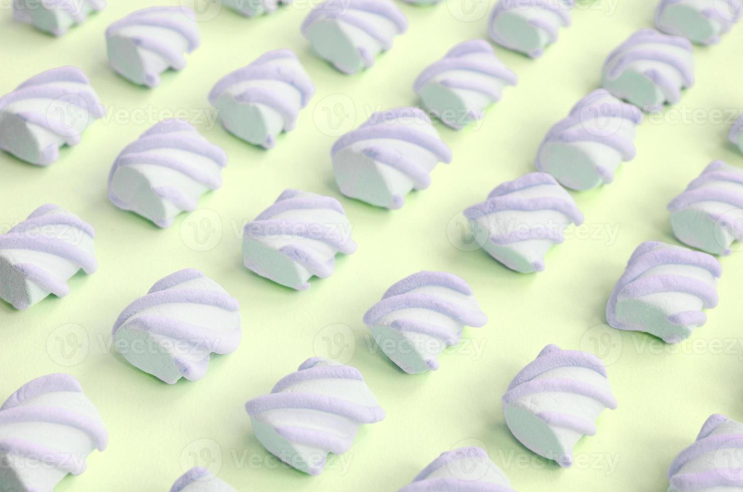 Colorful marshmallow laid out on lime paper background. pastel creative textured pattern photo