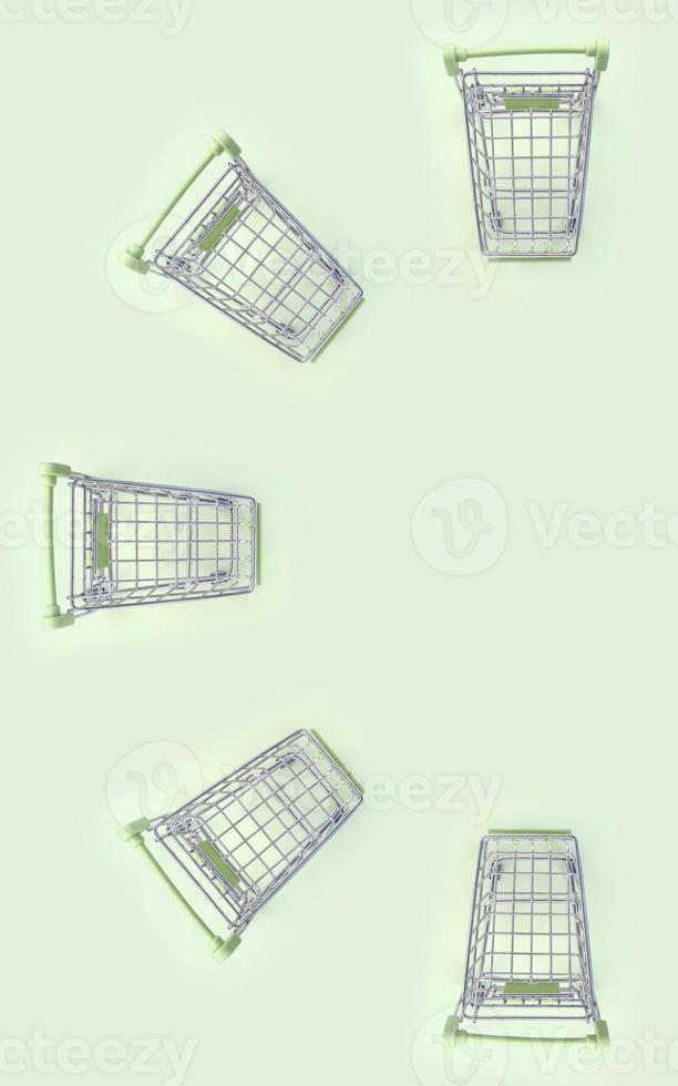 Pattern of many small shopping carts on a lime background photo