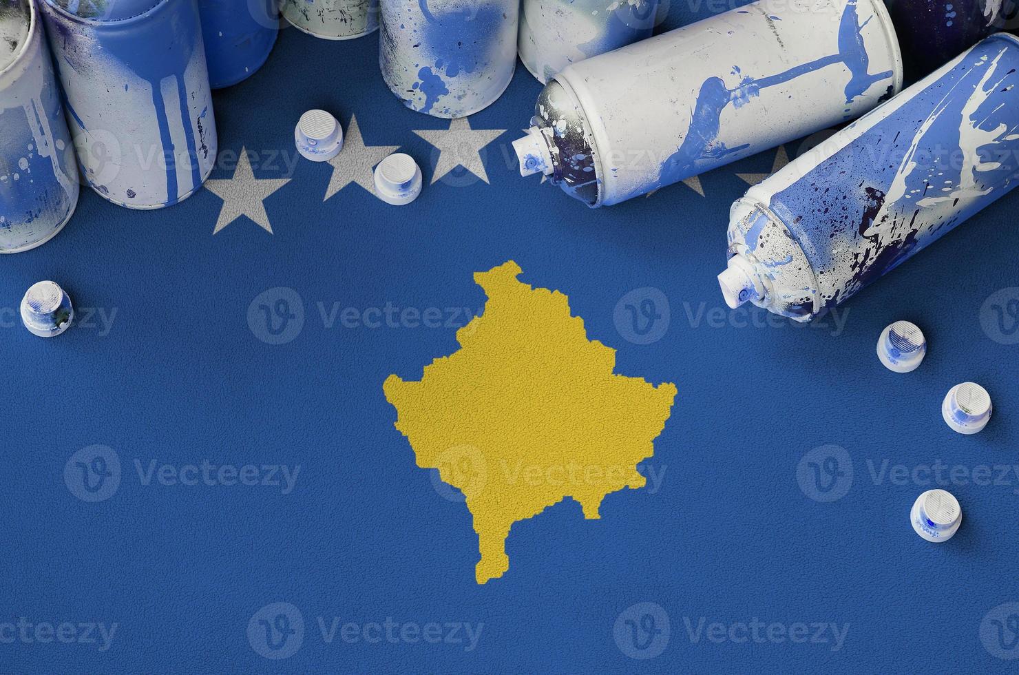 Kosovo flag and few used aerosol spray cans for graffiti painting. Street art culture concept photo