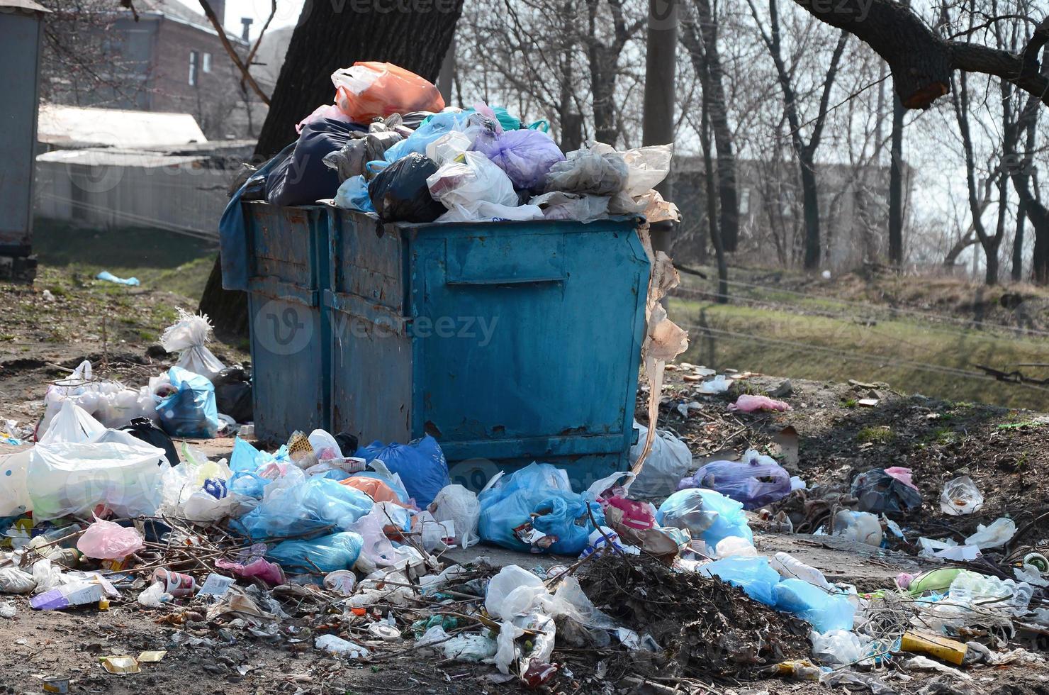 el bote de basura está lleno de basura y desechos. retiro intempestivo de basura en zonas pobladas foto