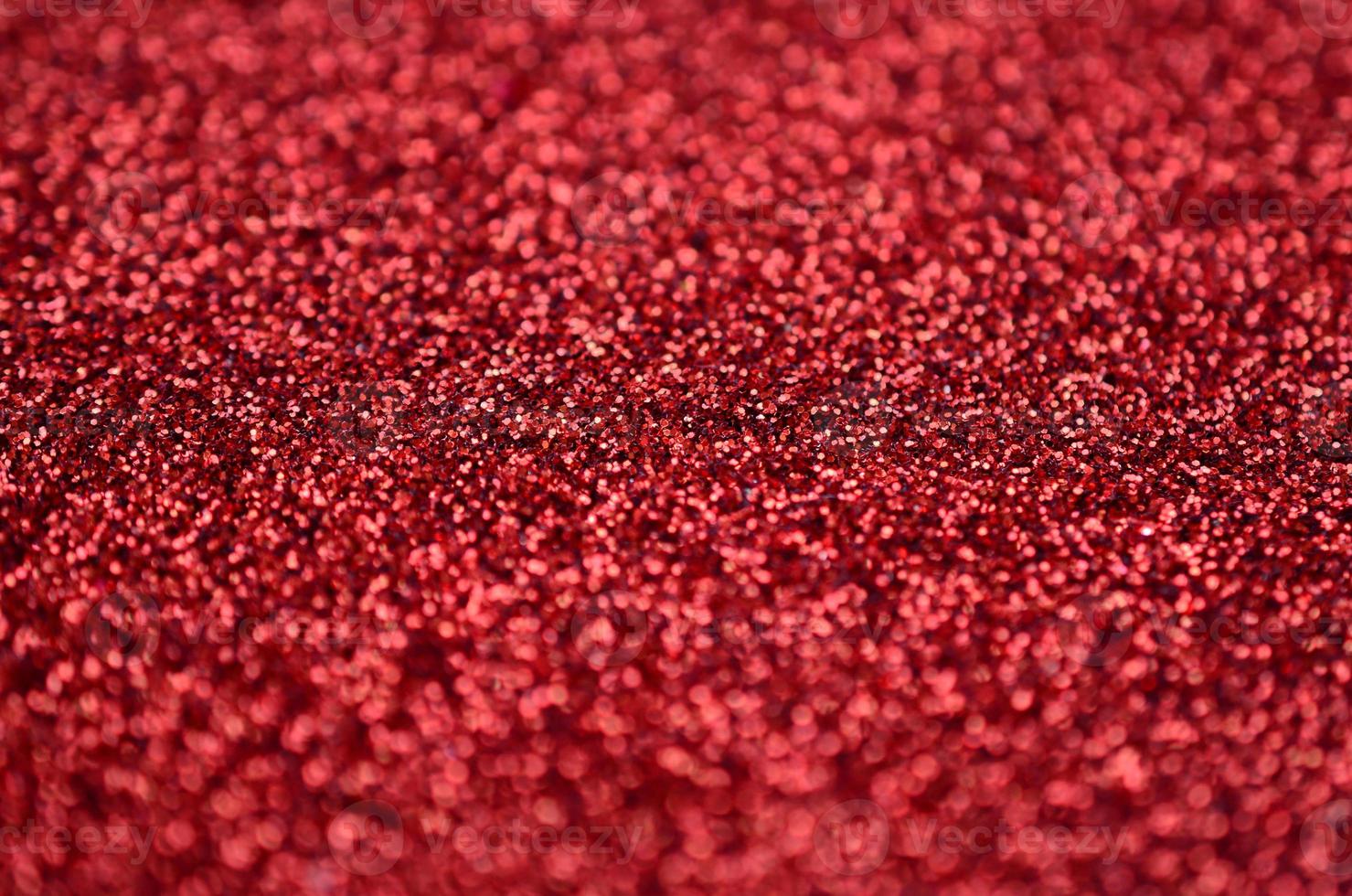 Crimson red decorative sequins. Background image with shiny bokeh lights from small elements photo