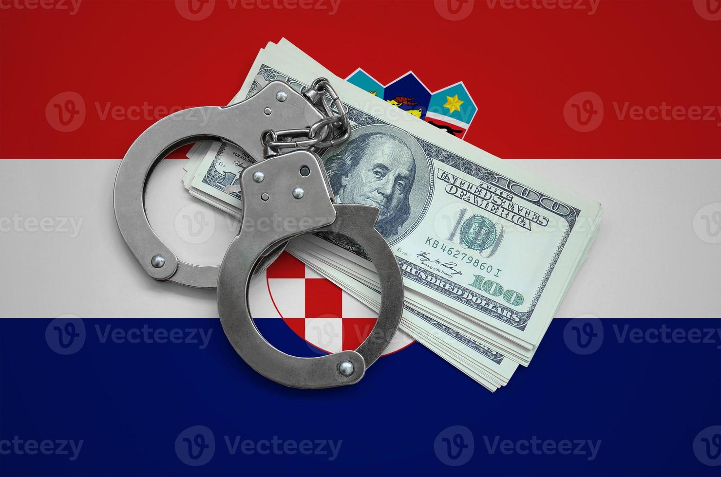Croatia flag with handcuffs and a bundle of dollars. Currency corruption in the country. Financial crimes photo